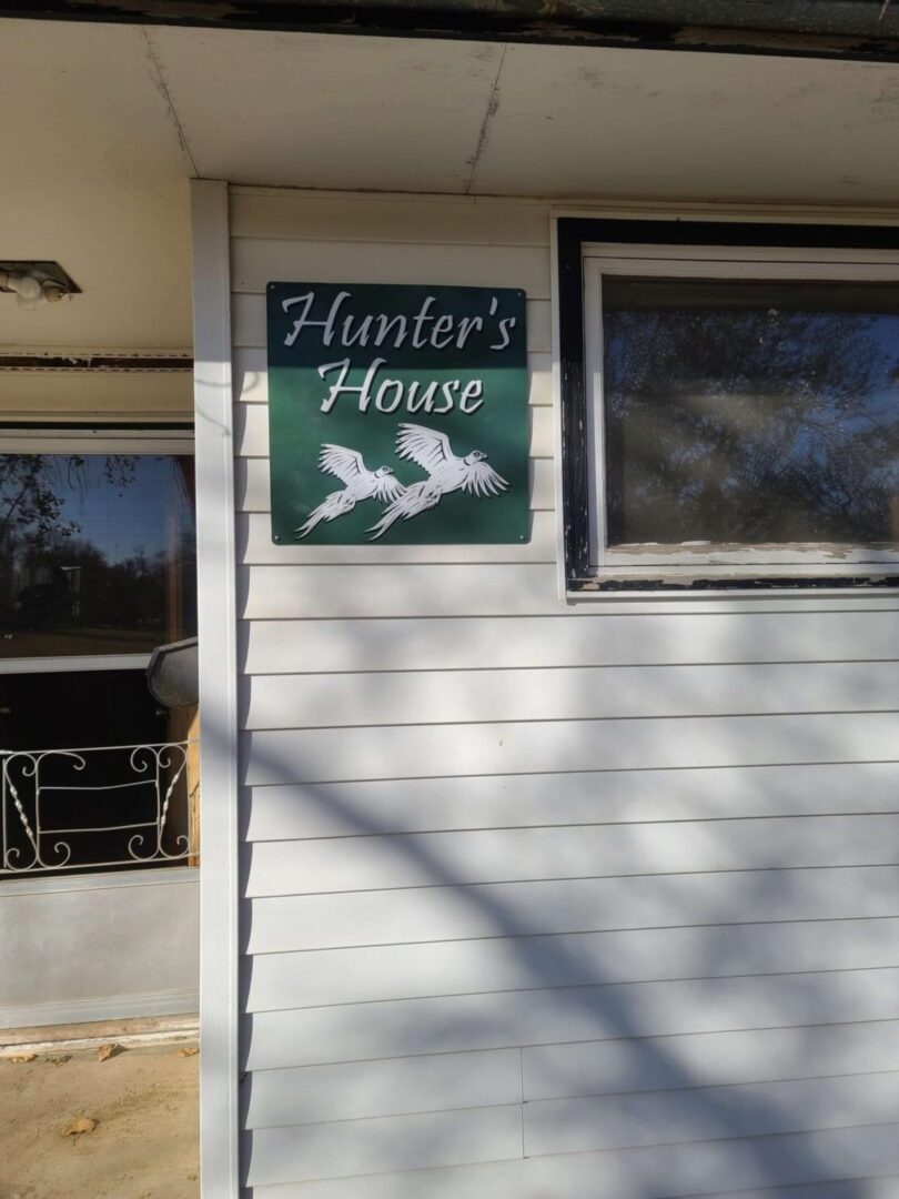 a sign with two birds that says hunter’s house