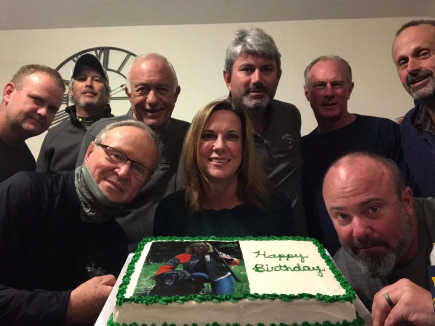 a group of people smiling with a birthday cake