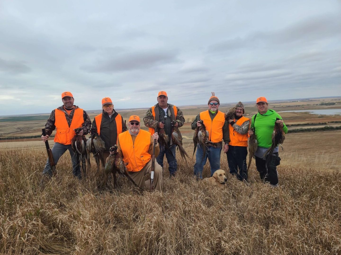 men and a dog at a pheasant hunting ground