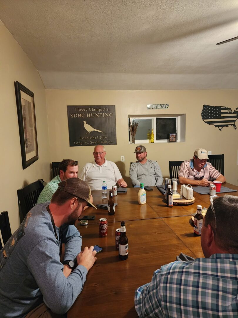 Hunting Team Sitting at Wooden Dining Table