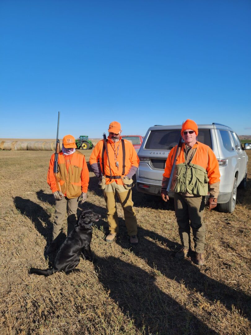 Three Hunters On The Field With Dog