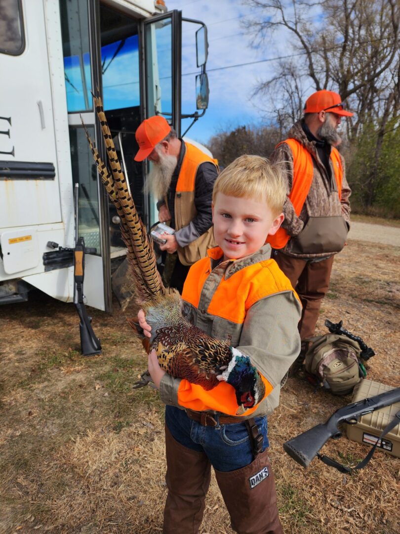 Kid Holding a Bird at Hunting Field