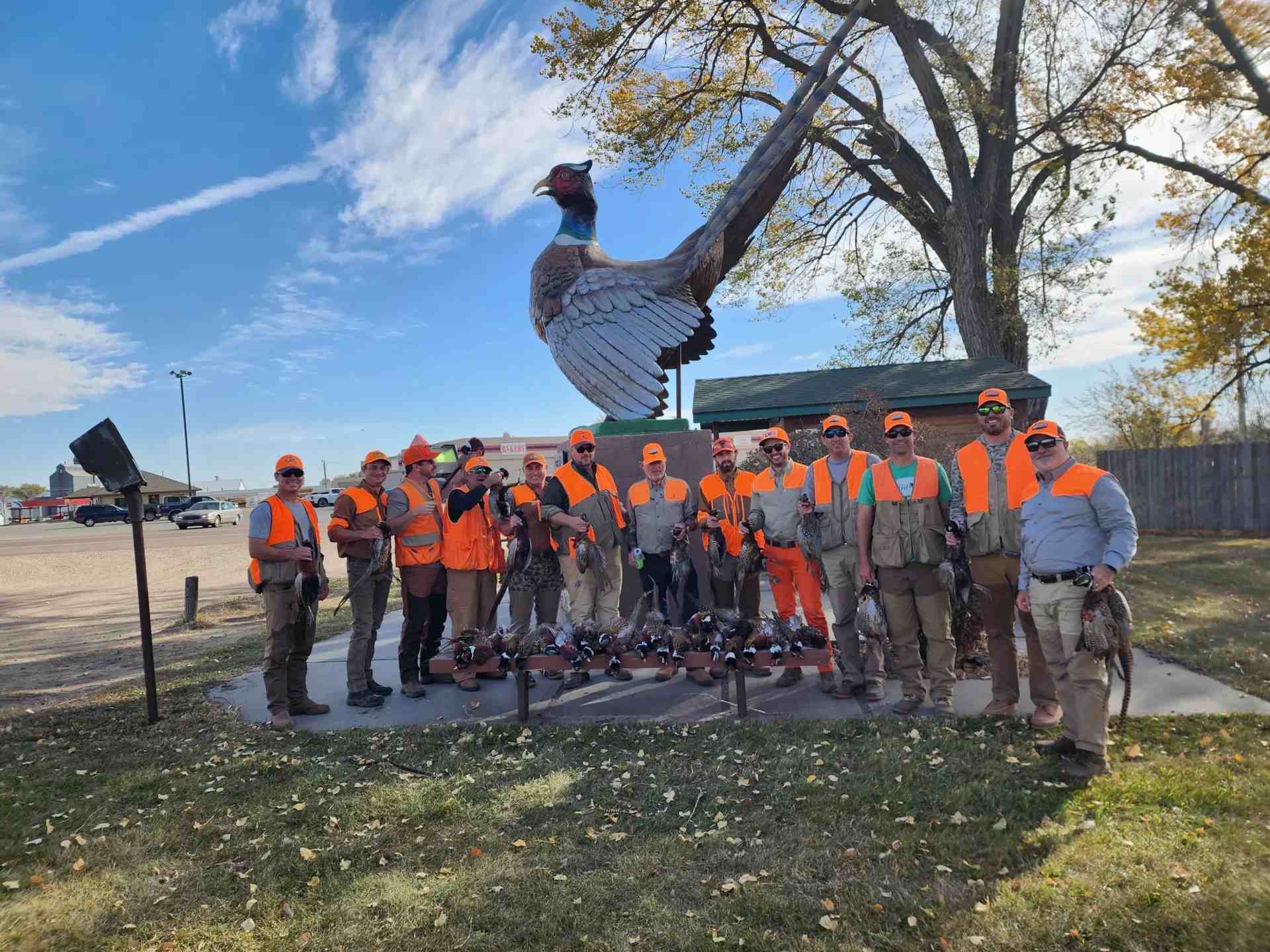 a group of hunters posing near a statue